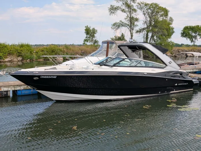  Yacht Photos Pics 2011 Monterey 328 SS boat docked on a calm lake with trees in the background.