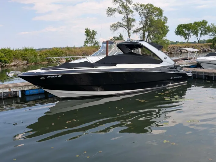  Yacht Photos Pics 2011 Monterey 328 SS boat docked on calm water, surrounded by greenery.