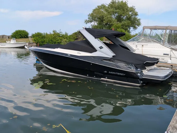  Yacht Photos Pics 2011 Monterey 328 SS boat docked on calm water, covered and ready for use.