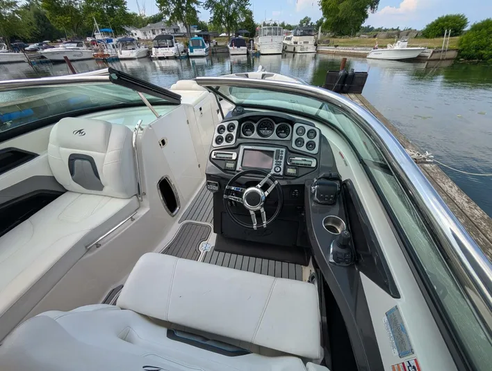  Yacht Photos Pics 2011 Monterey 328 SS boat interior with steering wheel, dashboard, and seating at a marina.