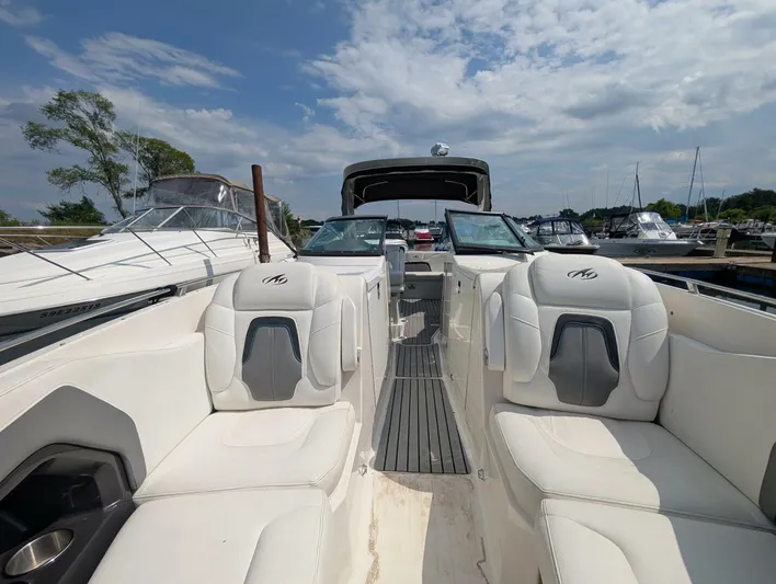  Yacht Photos Pics 2011 Monterey 328 SS boat interior with white seating, docked at a marina under a cloudy sky.