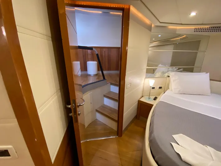 Uml Yacht Photos Pics Luxurious interior of 2007 Pershing 62' yacht, featuring a cozy bedroom and elegant wooden staircase.