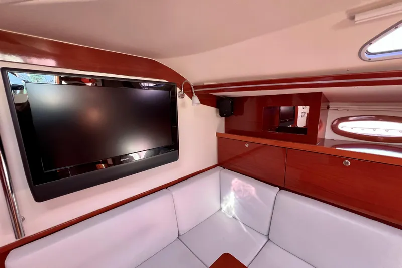 The Jonathan Shepard Yacht Photos Pics Interior of 2006 Hanse 461e yacht with TV, white seating, and wooden cabinetry.
