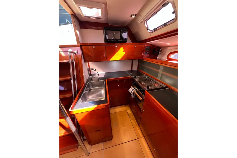 The Jonathan Shepard Yacht Photos Pics 2006 Hanse 461e yacht kitchen with wooden cabinetry, stainless steel sink, and stove.