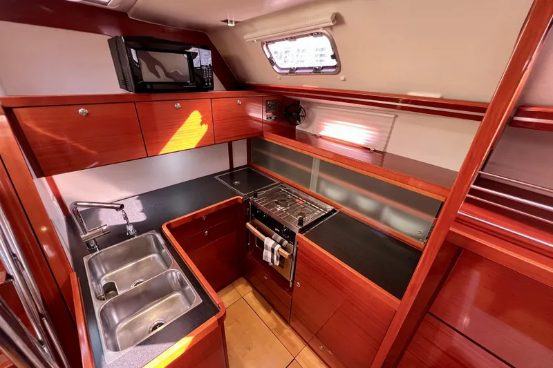 The Jonathan Shepard Yacht Photos Pics Luxurious 2006 Hanse 461e yacht kitchen with wood cabinetry, dual sinks, and modern appliances.