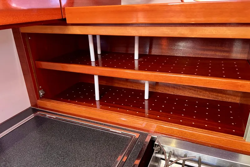 The Jonathan Shepard Yacht Photos Pics Wooden shelves in a 2006 Hanse 461e yacht kitchen, featuring perforated design.