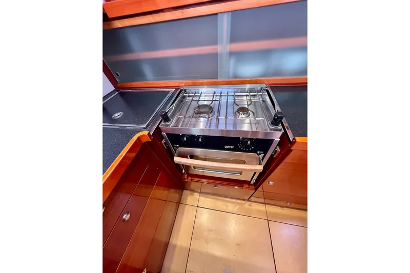 The Jonathan Shepard Yacht Photos Pics Compact kitchen area in a 2006 Hanse 461e yacht with a stainless steel stove.