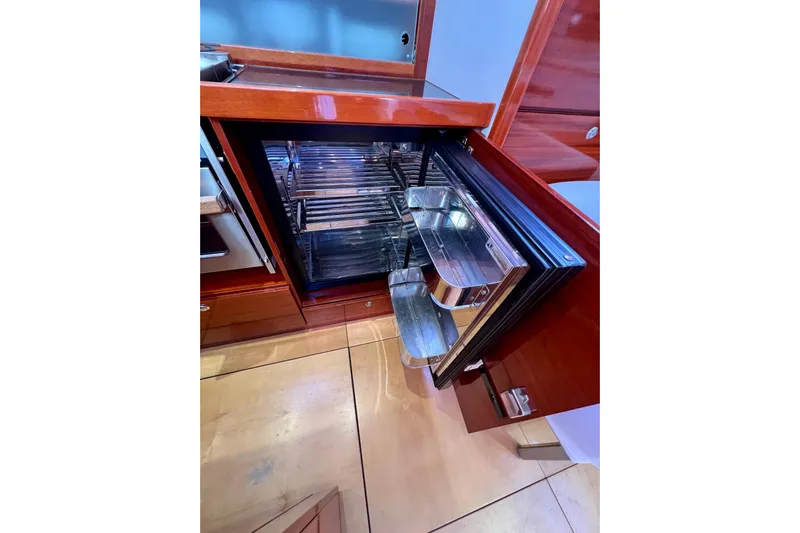 The Jonathan Shepard Yacht Photos Pics Open refrigerator in 2006 Hanse 461e yacht kitchen with wooden cabinetry.