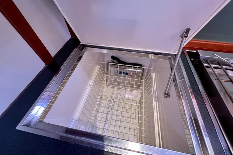 The Jonathan Shepard Yacht Photos Pics Open storage compartment on 2006 Hanse 461e yacht, featuring a wire basket and hydraulic hinge.