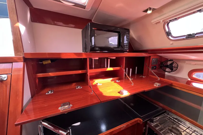 The Jonathan Shepard Yacht Photos Pics 2006 Hanse 461e yacht interior kitchen with microwave and wooden cabinetry.