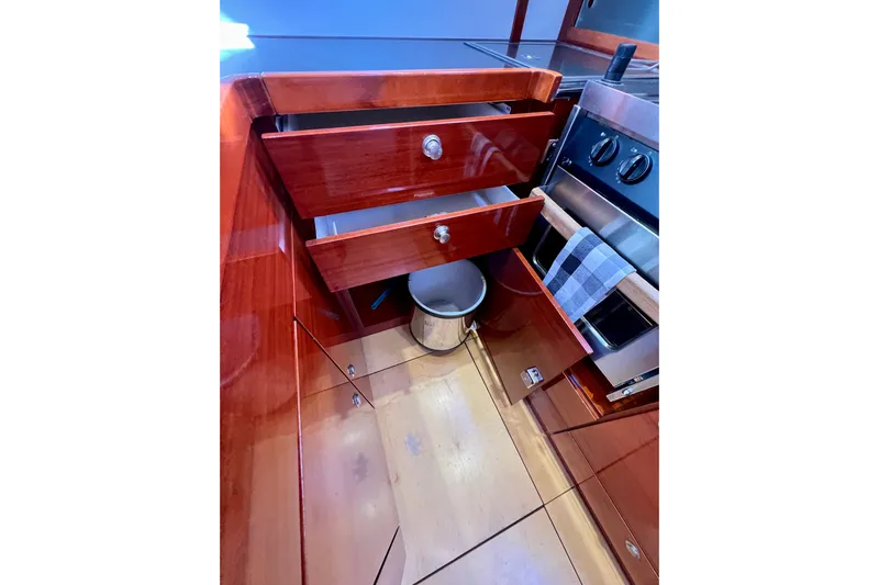 The Jonathan Shepard Yacht Photos Pics 2006 Hanse 461e yacht kitchen with open wooden drawers and stainless steel stove.