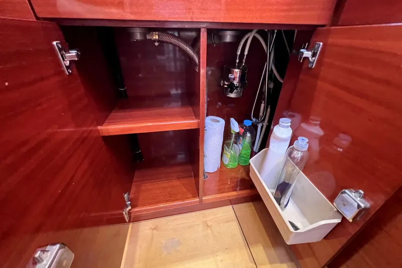 The Jonathan Shepard Yacht Photos Pics Wooden cabinet interior with cleaning supplies on a 2006 Hanse 461e yacht.