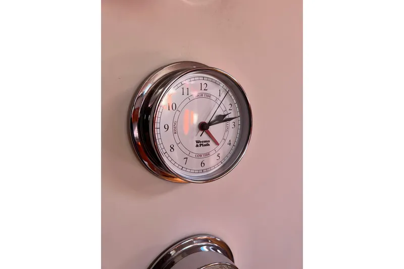 The Jonathan Shepard Yacht Photos Pics Chrome tide clock on 2006 Hanse 461e yacht interior wall.