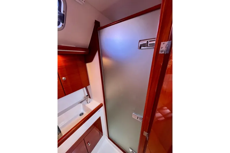 The Jonathan Shepard Yacht Photos Pics Luxurious bathroom interior of 2006 Hanse 461e yacht with wooden cabinetry and frosted glass door.