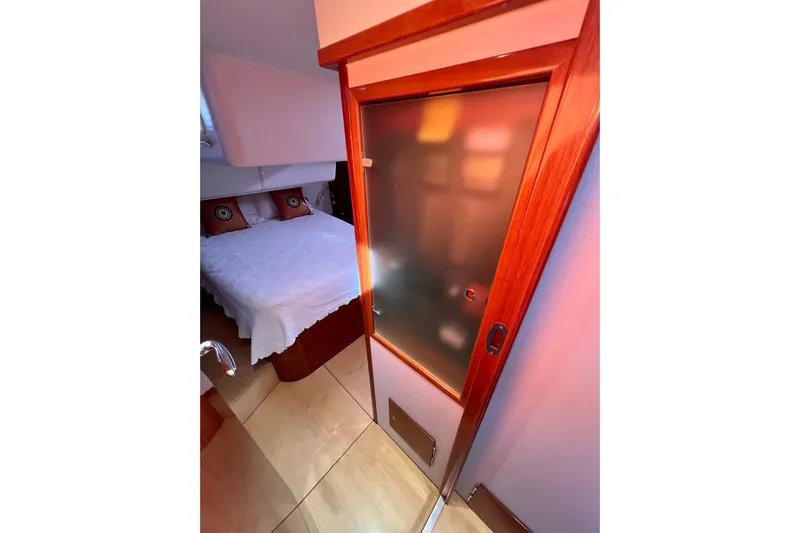 The Jonathan Shepard Yacht Photos Pics Cozy bedroom in 2006 Hanse 461e yacht with frosted glass door and elegant wood finish.