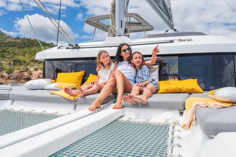  Yacht Photos Pics Family relaxing on a 2026 Lagoon 38 catamaran, enjoying a sunny day at sea.