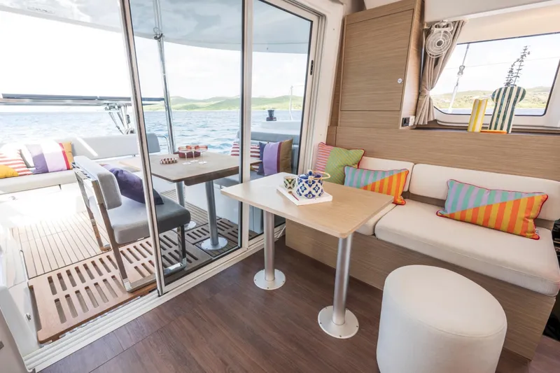  Yacht Photos Pics Modern interior of 2026 Lagoon 38 catamaran with colorful cushions and ocean view.