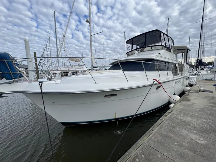 Grace Yacht Photos Pics 1995 Carver 440 Aft Cabin Motor Yacht docked at marina under cloudy sky.
