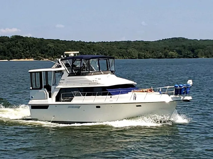 Grace Yacht Photos Pics 1995 Carver 440 Aft Cabin Motor Yacht cruising on a lake.