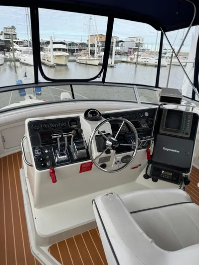 Grace Yacht Photos Pics 1995 Carver 440 Aft Cabin Motor Yacht helm with navigation equipment and marina view.