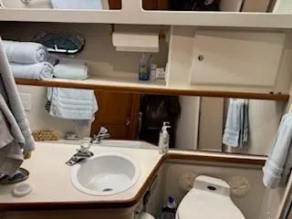 Grace Yacht Photos Pics 1995 Carver 440 Aft Cabin Motor Yacht bathroom with sink, toilet, and towels.