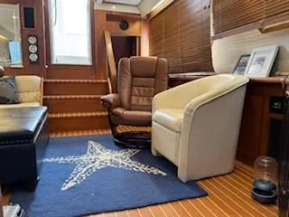 Grace Yacht Photos Pics Interior of 1995 Carver 440 Aft Cabin Motor Yacht with chairs and starfish rug.
