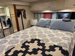 Grace Yacht Photos Pics 1995 Carver 440 Aft Cabin Motor Yacht bedroom with patterned bedding and cozy decor.