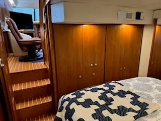 Grace Yacht Photos Pics 1995 Carver 440 Aft Cabin Motor Yacht interior with wood paneling and cozy bedding.