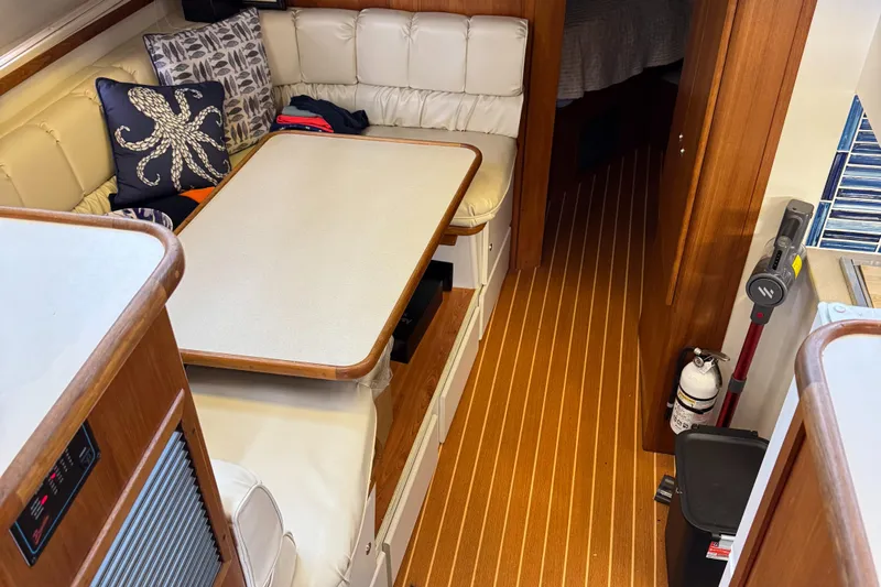 Grace Yacht Photos Pics 1995 Carver 440 Aft Cabin Motor Yacht interior with dining area and wooden flooring.