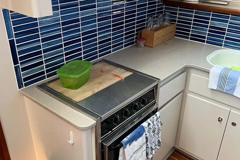 Grace Yacht Photos Pics Compact kitchen in a 1995 Carver 440 Aft Cabin Motor Yacht with blue tile backsplash.
