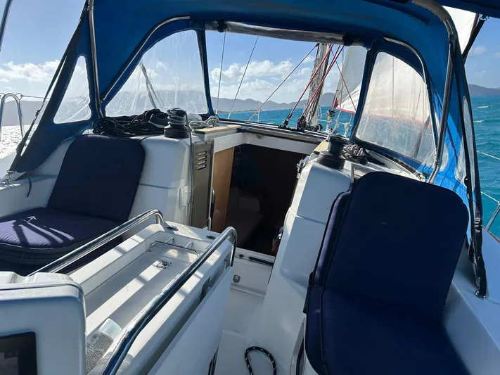 Layover Yacht Photos Pics Cockpit of 2018 Jeanneau Sun Odyssey 389 sailboat with blue canopy and seating.