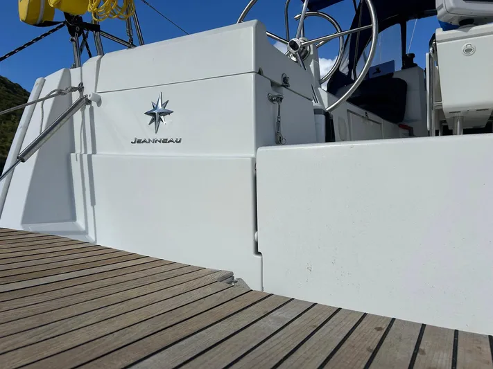 Layover Yacht Photos Pics 2018 Jeanneau Sun Odyssey 389 sailboat deck with steering wheel and wooden flooring.