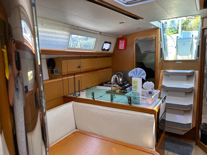 Layover Yacht Photos Pics Interior of 2018 Jeanneau Sun Odyssey 389 yacht, featuring a cozy dining area and modern kitchen.