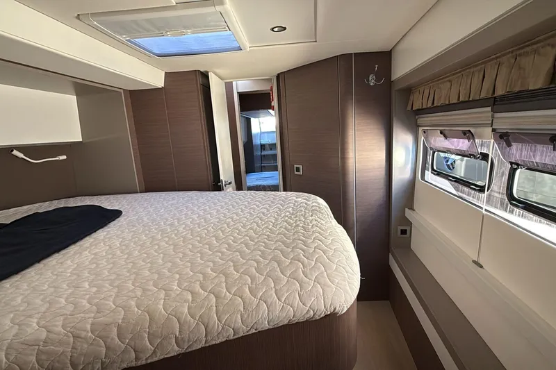  Yacht Photos Pics Luxurious interior of a 2021 Bali 5.4 yacht cabin with a cozy bed and windows.