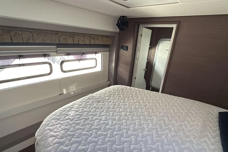  Yacht Photos Pics Interior of 2021 Bali 5.4 yacht bedroom with quilted bed and large windows.