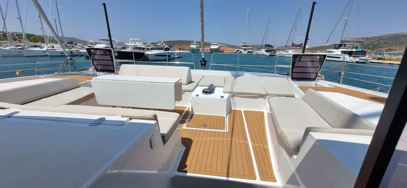  Yacht Photos Pics Luxurious 2024 Bali 5.4 yacht deck with comfortable seating, docked in a marina.