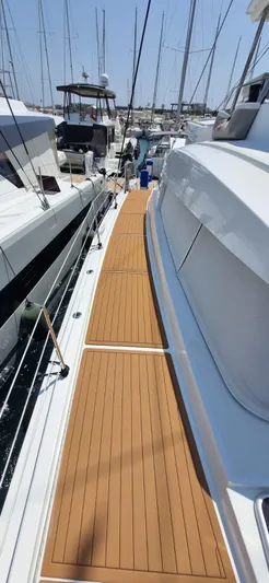 Yacht Photos Pics 2024 Bali 5.4 yacht deck with teak flooring, docked in a marina.