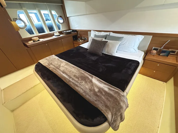 Primo Yacht Photos Pics Luxurious bedroom interior of 2014 Ferretti Yachts 530 with elegant bedding and porthole windows.