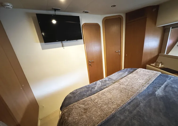 Primo Yacht Photos Pics Luxurious bedroom interior of 2014 Ferretti Yachts 530 with TV and wooden accents.