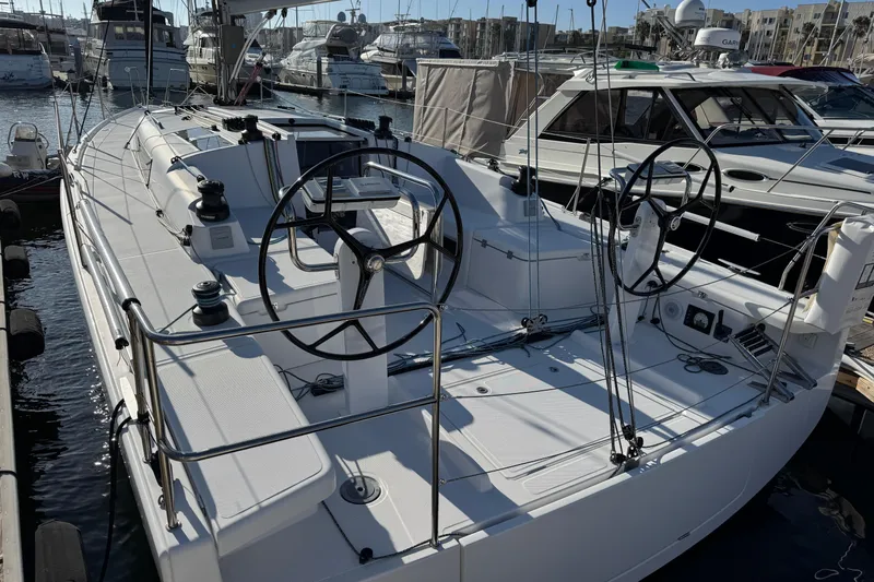  Yacht Photos Pics 2023 Beneteau First 36 sailboat docked in a marina, showcasing dual steering wheels.