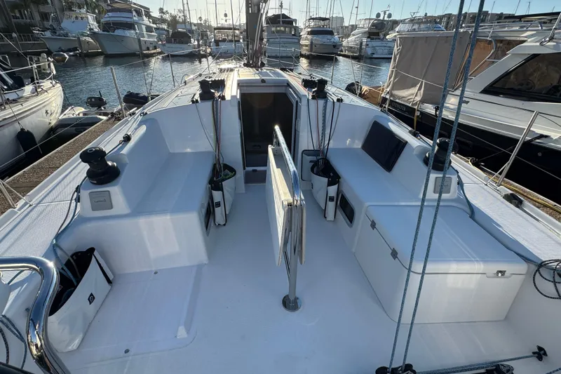  Yacht Photos Pics 2023 Beneteau First 36 sailboat cockpit, docked in a marina, showcasing sleek design and functionality.