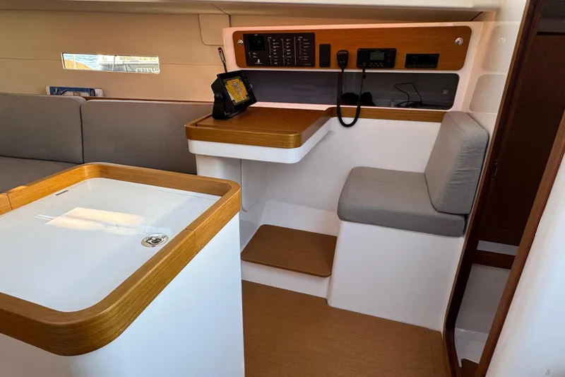  Yacht Photos Pics Interior of 2023 Beneteau First 36 sailboat with navigation station and seating area.