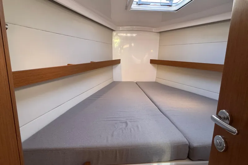  Yacht Photos Pics 2023 Beneteau First 36 cabin interior with cozy bedding and wooden accents.