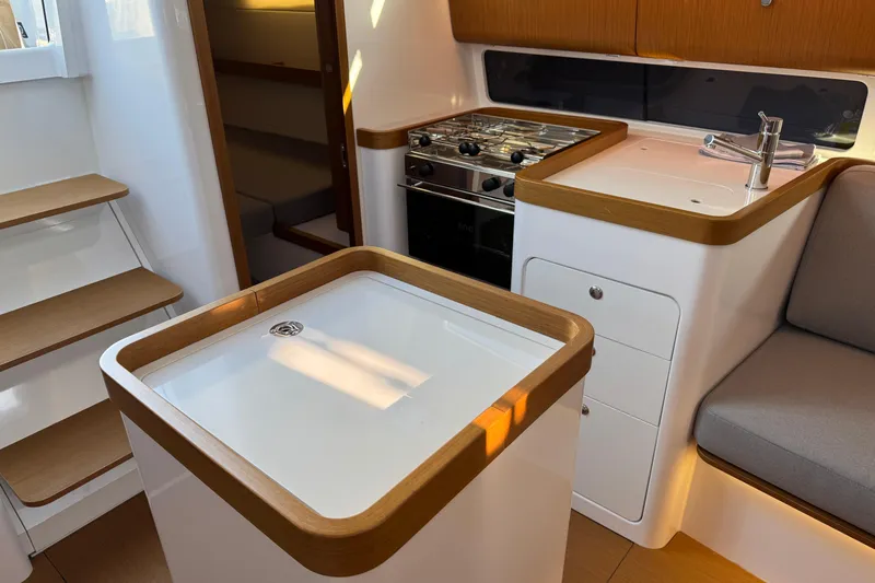  Yacht Photos Pics Modern interior of 2023 Beneteau First 36 yacht with kitchen and seating area.