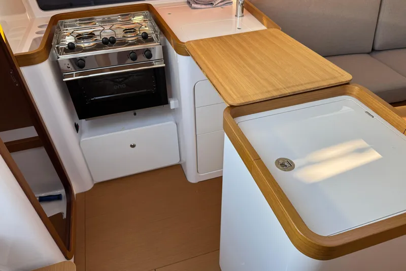  Yacht Photos Pics Modern kitchen area in 2023 Beneteau First 36 yacht, featuring stove and wooden countertops.