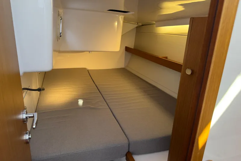  Yacht Photos Pics 2023 Beneteau First 36 cabin interior with cozy bed and wooden accents.