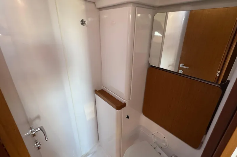  Yacht Photos Pics 2023 Beneteau First 36 yacht bathroom with modern fixtures and wooden accents.