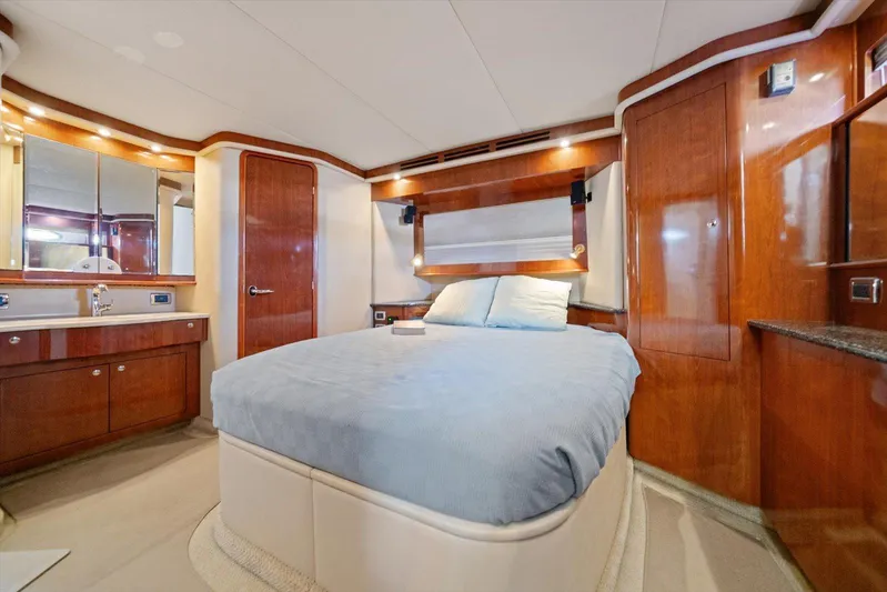 Free Bird Yacht Photos Pics Luxurious bedroom interior of 2003 Sea Ray 480 Motor Yacht with wood finishes and cozy bedding.