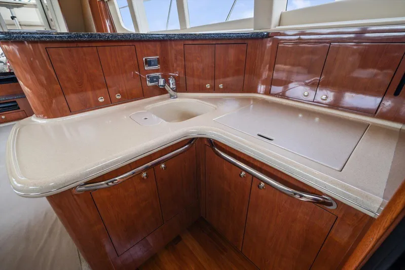 Free Bird Yacht Photos Pics Luxurious kitchen area in 2003 Sea Ray 480 Motor Yacht with wood cabinetry and sleek countertops.