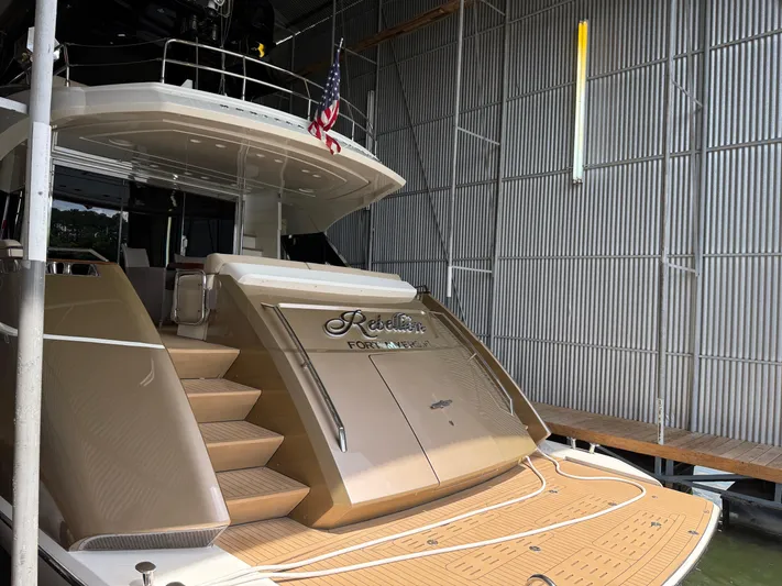 Rebellion Yacht Photos Pics Luxury Monte Carlo Yachts 76, 2012 model, docked with elegant design and American flag.